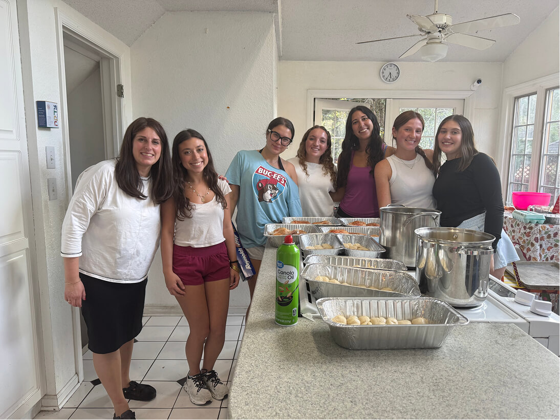 Students and the Rabbi preparing challah together in the Chabad House kitchen